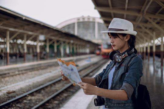 Young woman wearing hat with backpack looking of the mass rapid transit route map in train station for check next station for travel,travel concept,backpack,blurred background.