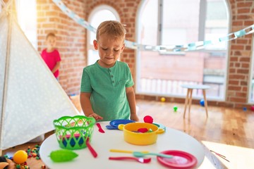 Adorable toddlers playing around lots of toys at kindergarten