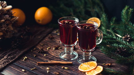 mulled wine in glasses on a wooden background with spices and ingredients with Christmas decor