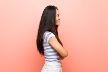 Teenager asian girl over isolated pink background in lateral position