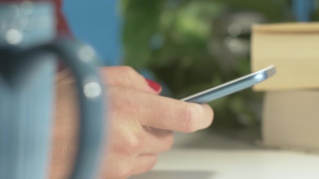 Extreme close up shot of a female hand browsing a smartphone