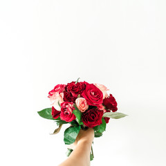 Female hand hold pink and red rose flowers bouquet isolated on white background. Holiday, Valentine's day present.