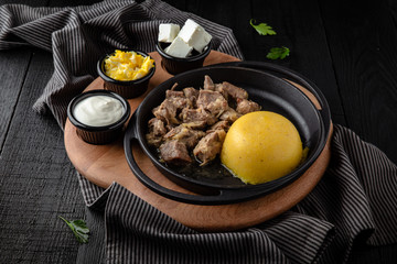 Hominy, corn porridge. Natural organic diet food. Tent with meat and cottage cheese. Restaurant menu. Background black boards.