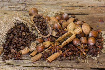 coffee beans, nuts and spices on old wooden background