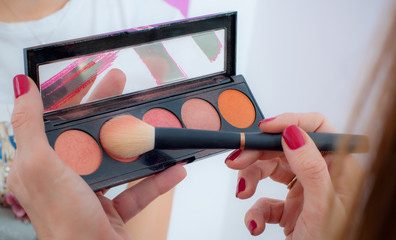 Makeup professional artist applying powder blush
