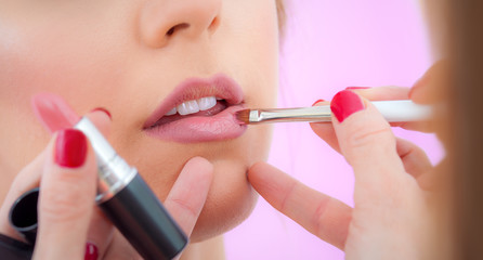 Professional lips make-up. Makeup professional artist applying lip gloss