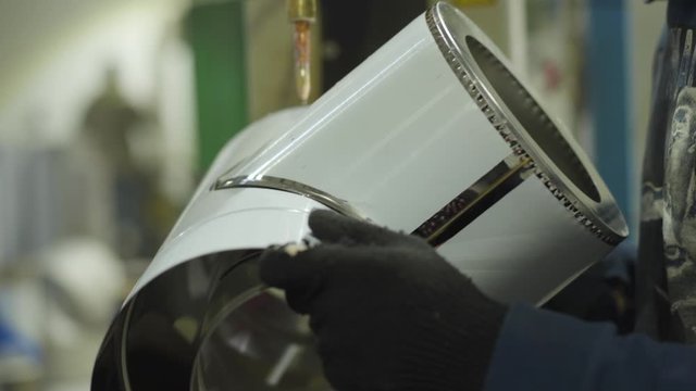 Side view of male hands holding metal cleanout and processing it with the use of riveting machine. Steel industry, steel production, manufacturing, industrial, equipment.