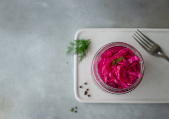 fermented cabbage with beets in a jar. top view, blurred background, copy space