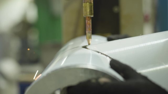 Close-up of metal product processing on hydraulic riveting machine. Steel industry, steel production, manufacturing, industrial, equipment.