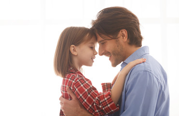 Close up portrait of father and daughter head to head