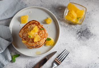 Tasty pancakes served with orange and mint. gray background, top view, horizontal image, copy space