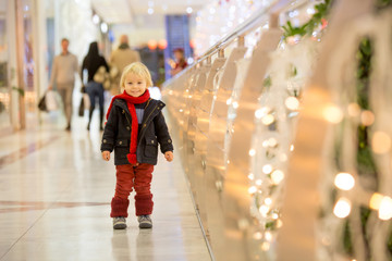 Fashion toddler boy in the city center shopping mall on Christmas