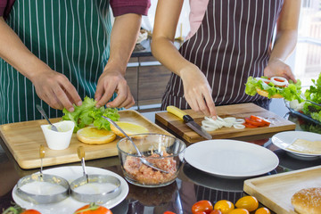 Asian couple making hamburgers together at home in holiday