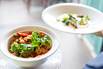 the waiter serves rice with vegetables