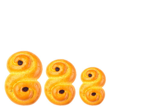 Traditional Swedish and scandinavian Christmas saffron buns Lussekatter, three in the row, isolated on white background, horizontal