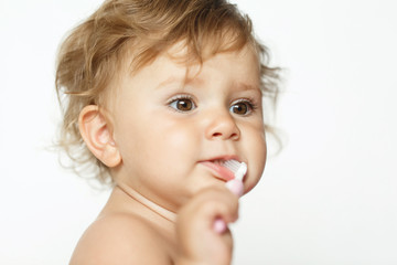 Adorable one year old child learning to brush teeth, isolated on white. Copy space