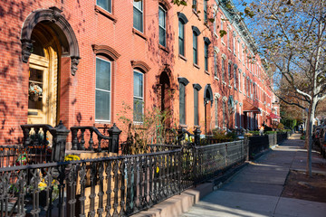 Fototapeta na wymiar Sidewalk and Row of Colorful Old Homes in Greenpoint Brooklyn New York