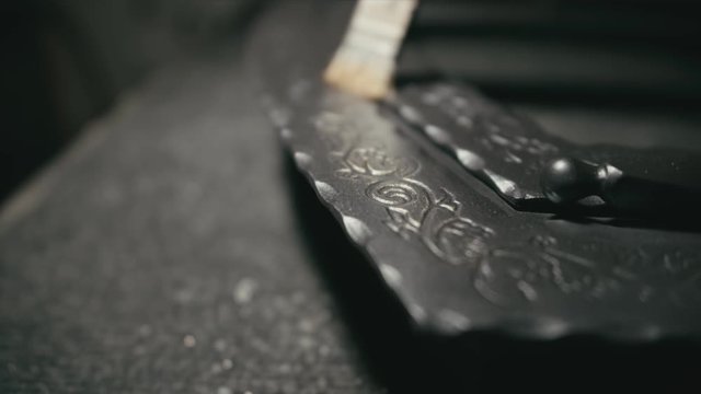 Forge workshop. Smithy manual production. The product is artificially aged. Gold powder painting of scratches, roughness and scuffs. Ageing. Aging processes. Pattern on iron. Carving ornament.