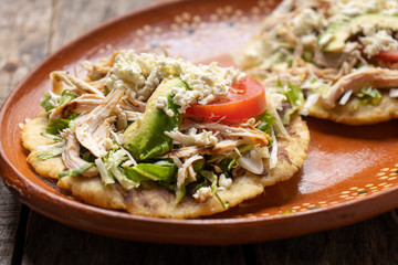 Yucatecan salbutes with chicken meat on wooden background