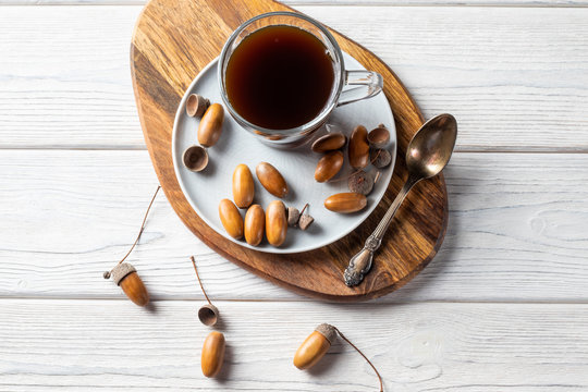 Acorn coffee in a glass is a tonic drink with a coffee flavor, rich color and pleasant aroma. On a white wooden background