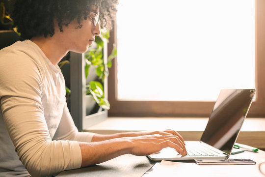Male copywriter typing social media content on laptop