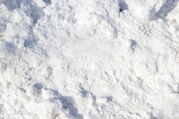 Fototapeta na wymiar A snow pile in a sunny day as a background