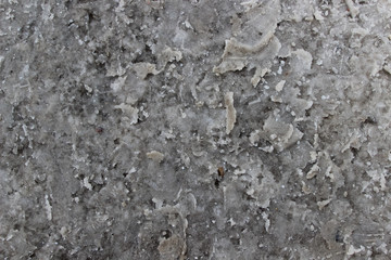 Dirty snow mixed with snow melting chemicals on the road as a background