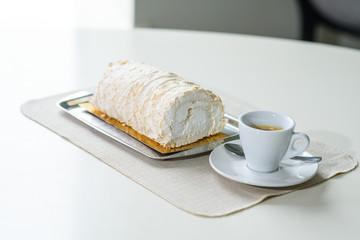 A delicious roll of bezrukov and a cup of coffee on a table in a cozy coffee shop