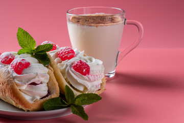Air cake with raspberries on a saucer. Kefir with cinnamon, fermented drink. Pink background