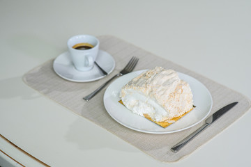 A delicious roll of bezrukov and a cup of coffee on a table in a cozy coffee shop