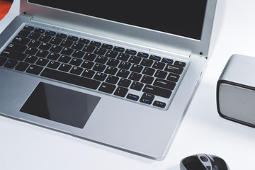 Laptop and speakers on the white table and mouse
