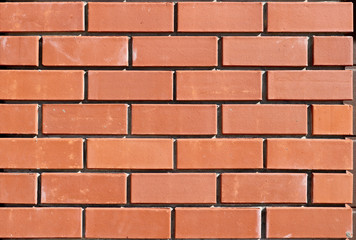 The texture of the new brickwork. Bricks background for design template. Brick wall. Close-up.