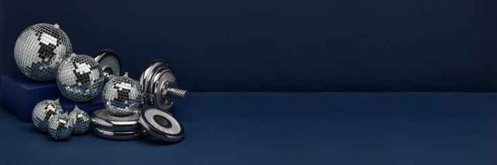 Dumbbell and mirror balls. Fitness New Year and Christmas background. Extra wide panorama banner background