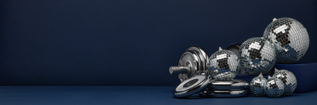 Dumbbell and mirror balls. Fitness New Year and Christmas background. Extra wide panorama banner background