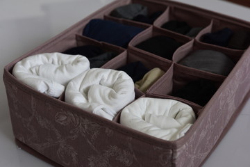 Fototapeta na wymiar Pink vintage drawer organizer filled with underwears and socks.
