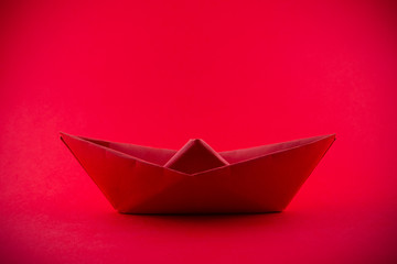 Paper boat isolated on red background
