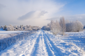 Fototapeta na wymiar car tracks in the snow on the winter road in sunny day
