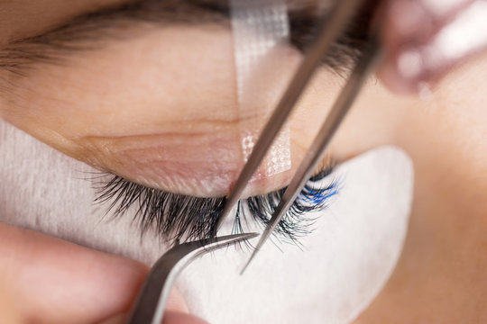 Woman on a cosmetic procedure for eyelash extension. Face and eyes close up.