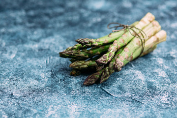 A bunch of green asparagus on a gray table
