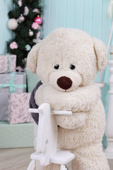 Modern interior design room with Christmas and New Year decorations, toys, gifts, fir tree, hanging swing. Winter holidays composition.