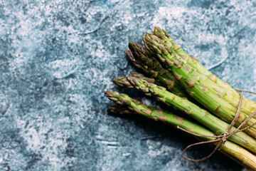 A bunch of green asparagus on a gray table