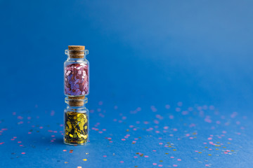 New Year and Christmas holiday blue background. Holidays,shopping and sales concept. Two small glass bottles with confetti