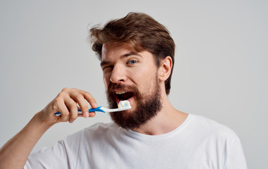man brushing his teeth isolated on white background