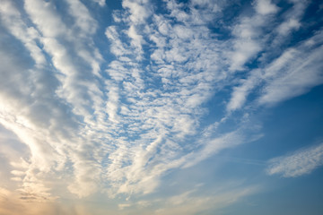 Blue sky background with tiny stratus cirrus striped clouds. Clearing day and Good windy weather