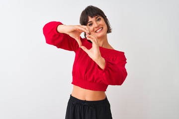 Young beautiful woman wearing red summer t-shirt standing over isolated white background smiling in love doing heart symbol shape with hands. Romantic concept.