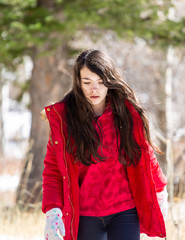 Girl walking in a snowy path in a forest