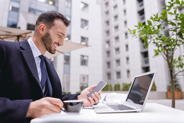 Joyful bearded male person working with pleasure