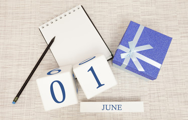 Calendar with trendy blue text and numbers for June 1 and a gift in a box.