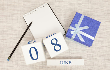 Calendar with trendy blue text and numbers for June 8 and a gift in a box.
