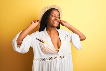 Beautiful african american girl wearing bikini and summer hat smiling happy